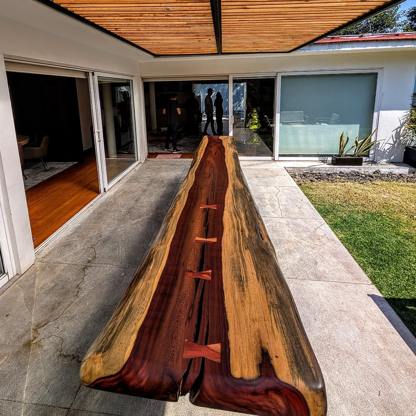 Long river-style live-edge table with bowtie inlays viewed down its length
